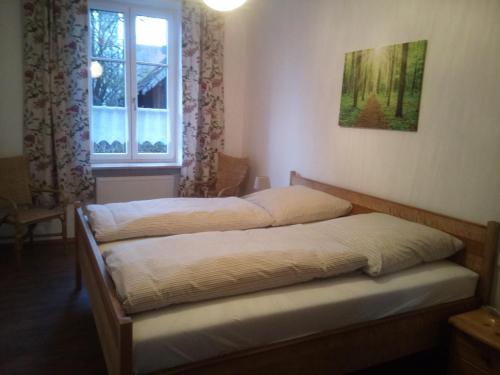 - 2 lits dans une chambre avec fenêtre dans l'établissement Ferienwohnung Kopold "Im alten Schulhaus", à Pöttmes
