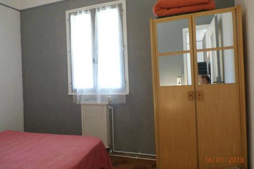 - une chambre avec une armoire en bois et une fenêtre dans l'établissement Location avec piscine et parking (n°2p), à Argelès-sur-Mer