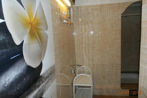 La salle de bains est pourvue d'une peinture florale sur le mur. dans l'établissement Location avec piscine et parking (n°2p), à Argelès-sur-Mer