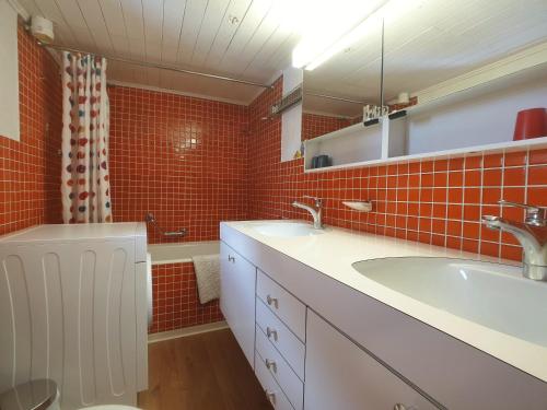 y baño con lavabo y azulejos rojos. en Hannig, en Saas-Fee
