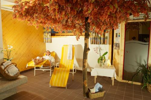 a man laying in a bed under a tree at Appartement Mühle - including Summercard, Sauna, Kaprun's largest private garden with panoramic view in Kaprun