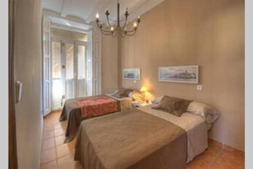 1 dormitorio con 2 camas y lámpara de araña en Main Central Station Apartment en Valencia