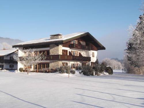 ein großes Haus mit Schnee auf dem Boden in der Unterkunft Landhaus Pichler in Ruhpolding