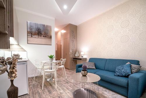 uma sala de estar com um sofá azul e uma mesa em Apartmán LIANA Hrebienok C106 em Starý Smokovec