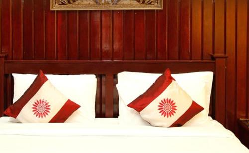 a bedroom with a bed with red and white pillows at Rajapruek Samui Resort - SHA Plus in Lipa Noi