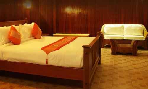 a hotel room with a bed and a chair at Rajapruek Samui Resort - SHA Plus in Lipa Noi