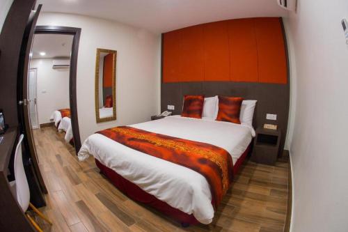 1 dormitorio con 1 cama grande y espejo grande en D'Spark Hotel Bayu, en Klang