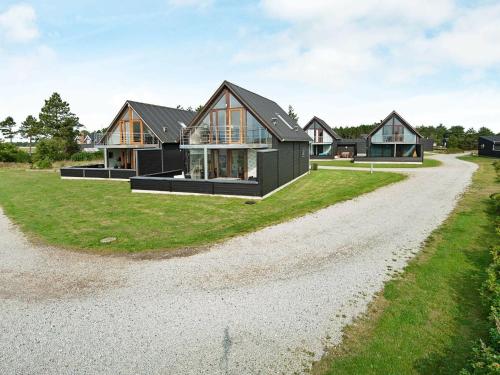 a house on a hill with a gravel driveway at 6 person holiday home in R m in Rømø Kirkeby