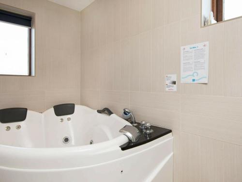 a white bath tub in a bathroom with a window at 6 person holiday home in R m in Rømø Kirkeby
