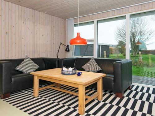 a living room with a couch and a table at 8 person holiday home in Ebeltoft in Ebeltoft