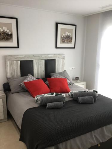 a bedroom with a large bed with red pillows at villa nathania in Rojales