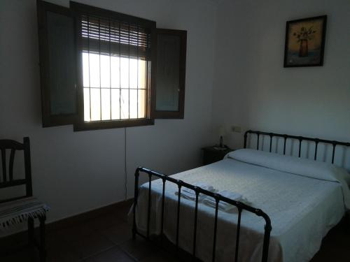 a bedroom with a bed and a window at Casa Rural La Loma in Iznájar
