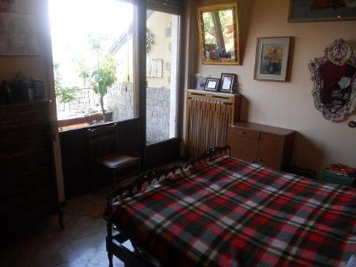a bedroom with a bed with a plaid blanket at Terrazza con Vista Grande in Laveno-Mombello