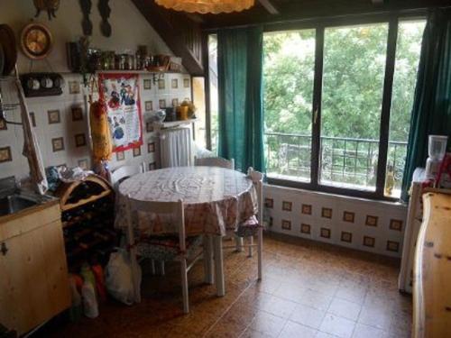 a kitchen with a table in a room with windows at Terrazza con Vista Grande in Laveno-Mombello