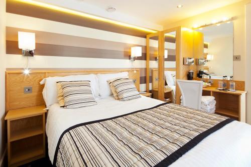 Schlafzimmer mit einem Bett, einem Schreibtisch und einem Spiegel in der Unterkunft Queens Mansions: Queens Suite in Blackpool