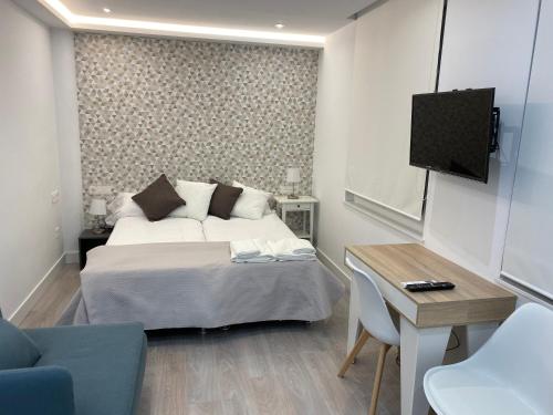 a bedroom with a bed and a table and a tv at WILLMARk 1 in Salamanca