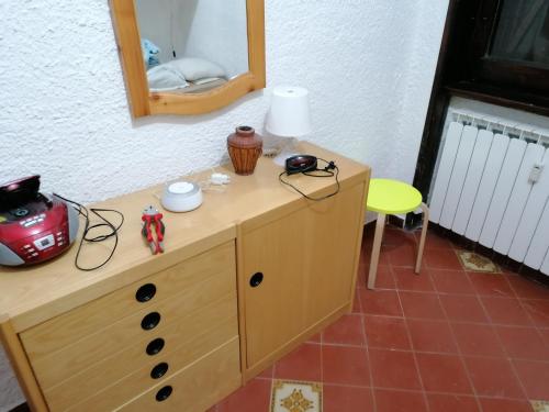 Vestidor de madera con espejo y silla amarilla en Residence La baita, en Rivisondoli