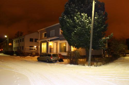 a car parked in front of a house in the snow at Käytännöllinen huoneisto Pietarsaaressa in Pietarsaari