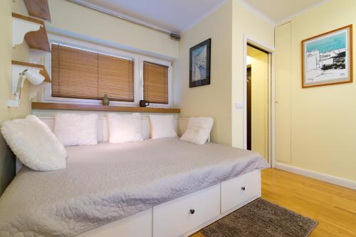 een slaapkamer met een bed met witte kussens en een raam bij Studio Batory in Kazimierz Dolny