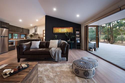 a living room with a couch and a table at Kurrajong Retreat in Hepburn Springs