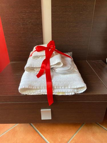 una scatola regalo con un nastro rosso sopra. di Casa di titti a Salerno
