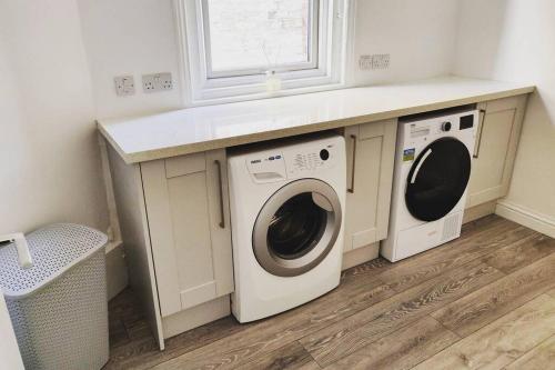 lavadero con lavadora y secadora bajo una barra en New 1 Bed First Floor Flat in Central Fareham, en Fareham