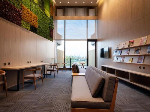a waiting room with a couch and chairs and a window at Fame Hall Garden Hotel in Longtan