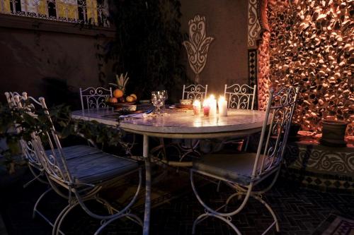 a table with two chairs and candles on it at Riad Ouarzazate in Ouarzazate