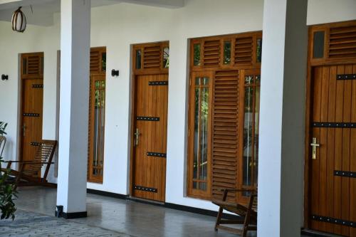 a row of wooden doors on a building at Buddika Safari & Resort in Udawalawe