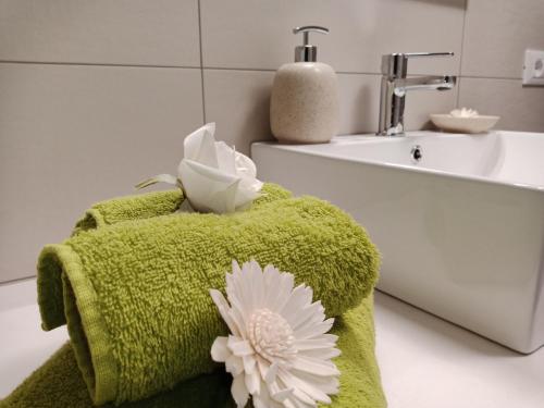 a bathroom with green towels and a sink at Appartamento "Il Vicolo" in Peschiera del Garda