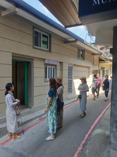 a group of women standing outside of a building at Jiufen Let's go Bed and Breakfast in Jiufen