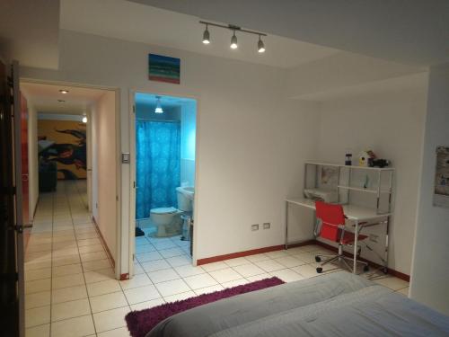 1 dormitorio con cama, escritorio y silla en Naths Apartment, en Guatemala