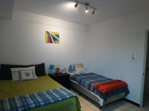 1 dormitorio con 2 camas contiguas en Naths Apartment, en Guatemala