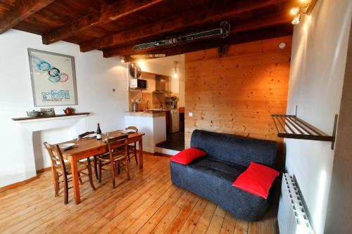 ein Wohnzimmer mit einem blauen Sofa und einem Tisch in der Unterkunft petite maison à Huez in Huez