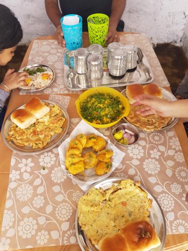 a table with many plates of food on it at Jandyal Farm House in Malshej Ghat