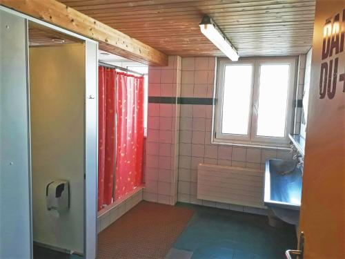 a bathroom with a shower and a sink and a window at juhui Arosa in Arosa