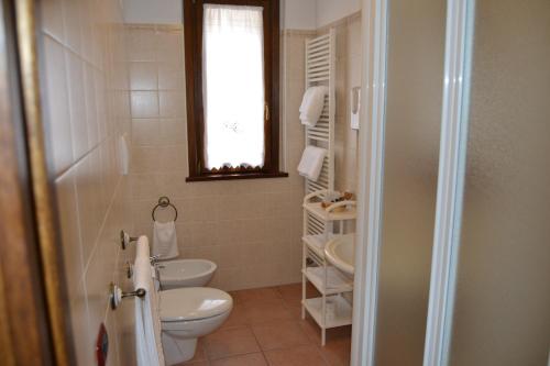 a bathroom with a toilet and a sink and a window at Villa Celeste in Rocca Pia