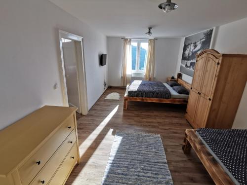 a bedroom with two beds and a dresser in it at Penzion Loučka Bystřice in Bystrzyca