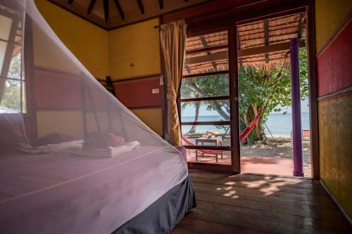 a bed in a room with a view of the ocean at Monkey Island Resort Koh Mak in Ko Mak