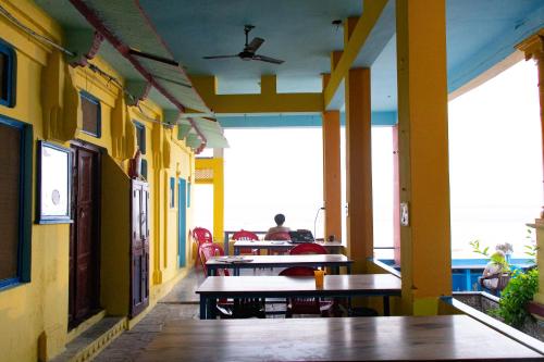 ein Zimmer mit Tischen und eine Person am Tisch in der Unterkunft Vishnu Rest House in Varanasi