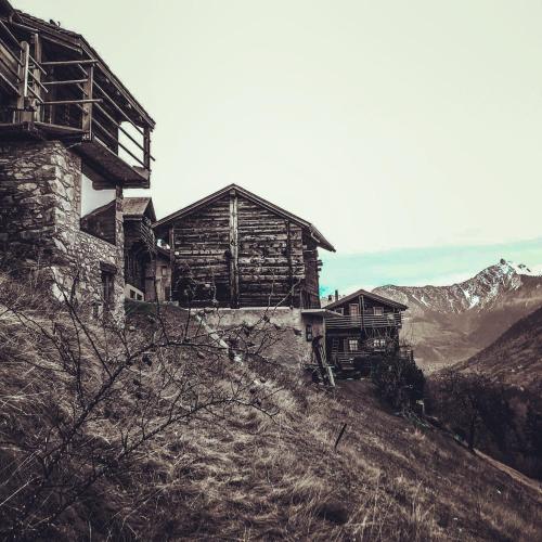 a group of buildings on top of a mountain at Chalet Le Biolley in Orsières