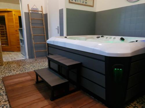 a bathroom with a bath tub with a sink at Cosy Er Lann Chambres d'Hôtes in Val Couesnon