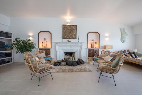 a living room with a couch and a fireplace at Sandhi House - Yoga & Wellness in Ericeira
