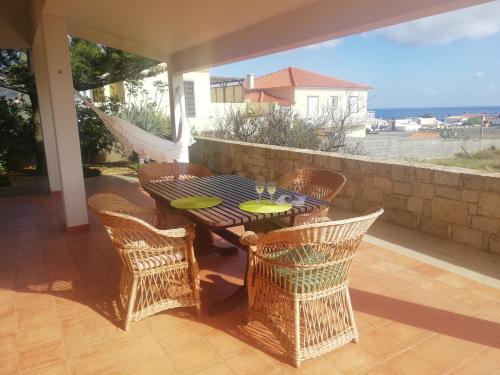 a patio with a table and chairs and a hammock at Quintinha das Lombas in Porto Santo