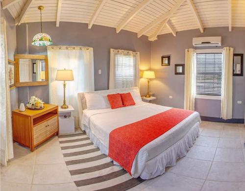 a bedroom with a large bed and two windows at Papaya Inn in Oranjestad