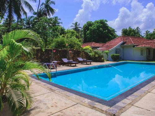 a swimming pool in front of a house at Thalpe Walawwa Heritage Villa With Private Beach Access in Unawatuna
