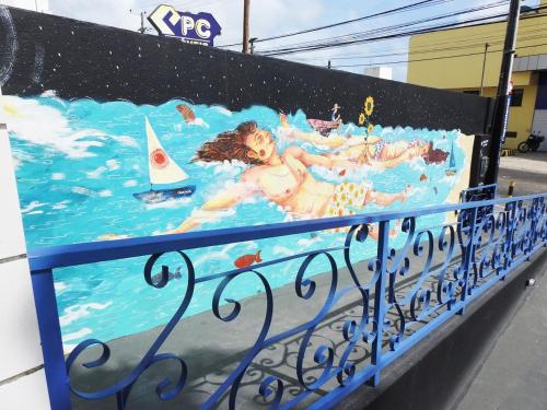 uma pintura de pessoas nadando em uma piscina em Soul Hostel Natal em Natal