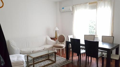 sala de estar con sofá blanco, mesa y sillas en Alquiler temporario en Recoleta Palermo en Buenos Aires