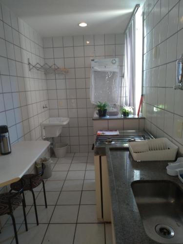 a small kitchen with a sink and a toilet at Apart Hotel Quartier Latin in Vitória