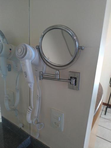 a bathroom with two hair dryers and a mirror at Apart Hotel Quartier Latin in Vitória